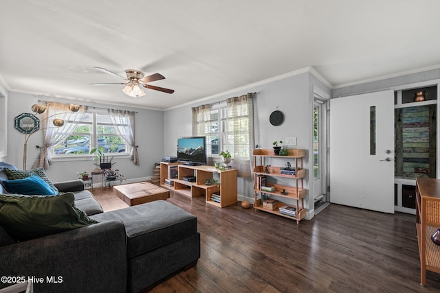 living room with dark wood-type flooring, baseboards, a ceiling fan, and crown molding