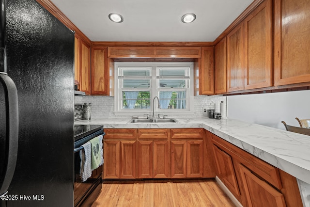 kitchen featuring black appliances, brown cabinets, and a sink