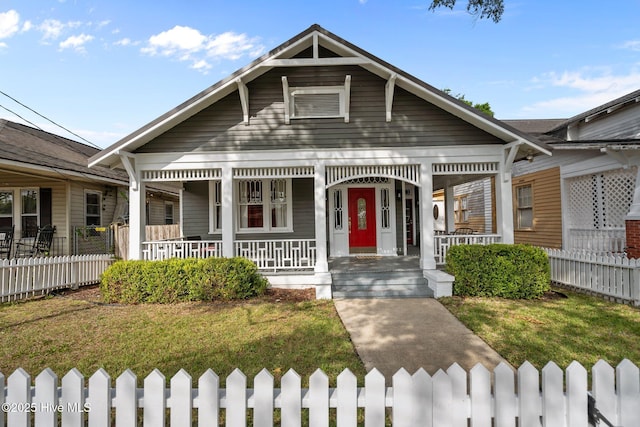 view of front facade featuring a porch, fence private yard, and a front yard
