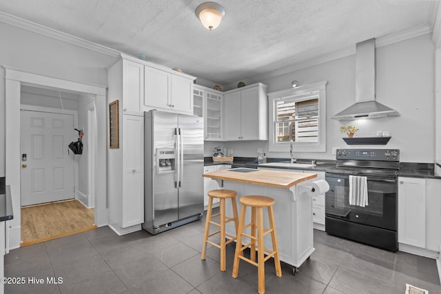 kitchen featuring wall chimney range hood, electric range, crown molding, stainless steel fridge with ice dispenser, and wood counters