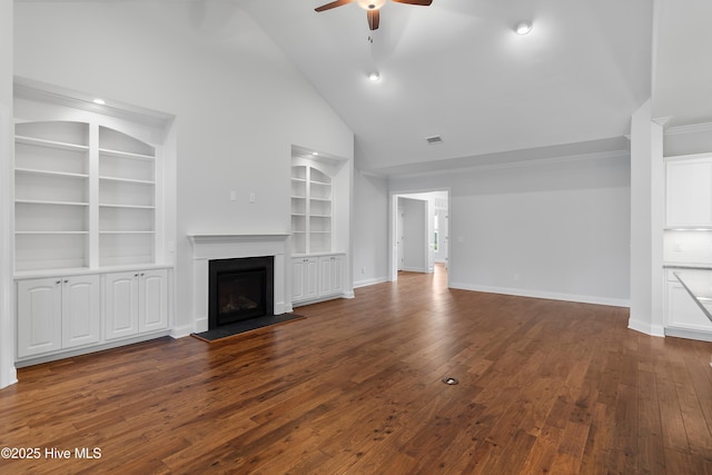 unfurnished living room featuring ceiling fan, a fireplace, dark wood finished floors, built in shelves, and high vaulted ceiling