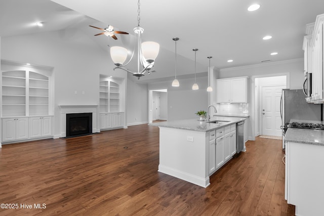 kitchen with ceiling fan, built in features, a sink, open floor plan, and white cabinetry
