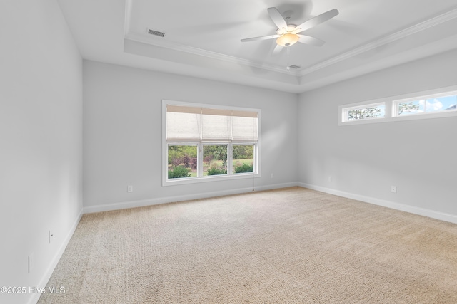 unfurnished room featuring a ceiling fan, a raised ceiling, baseboards, carpet floors, and ornamental molding