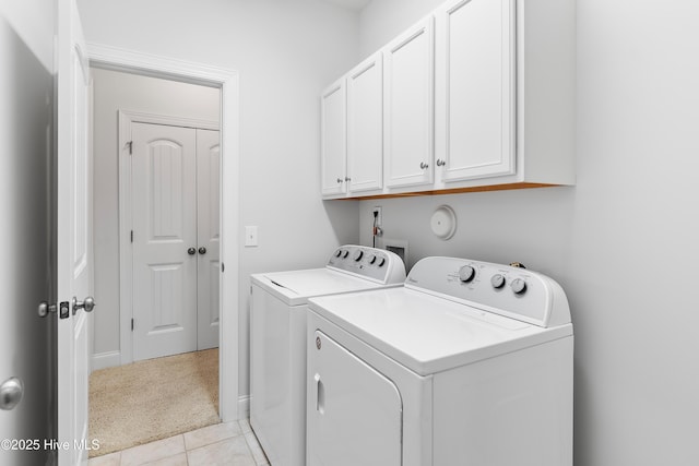 laundry area with light tile patterned floors, cabinet space, and washer and clothes dryer