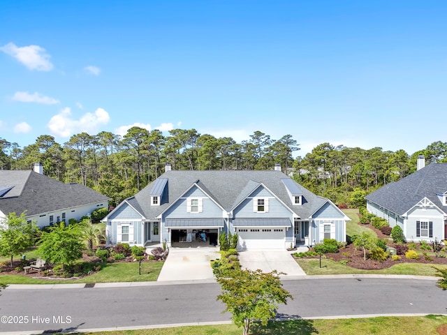 multi unit property featuring a standing seam roof, driveway, and metal roof