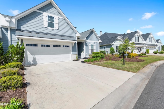view of front of property featuring a residential view, a garage, a standing seam roof, driveway, and metal roof
