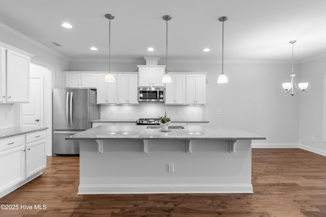 kitchen with ornamental molding, light stone countertops, white cabinetry, tasteful backsplash, and appliances with stainless steel finishes