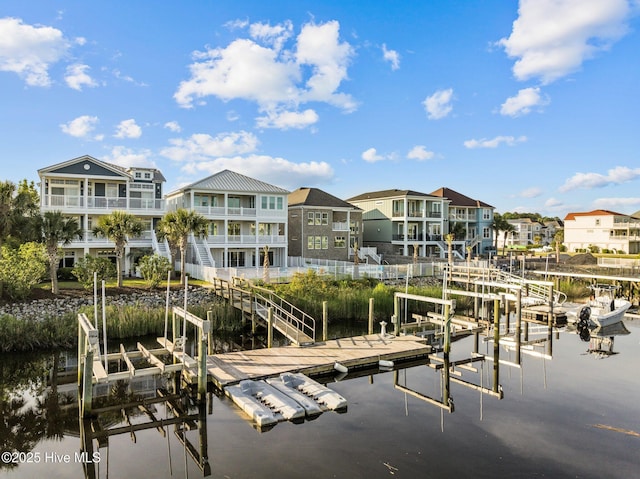 view of dock featuring a residential view, a water view, and boat lift