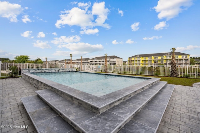 view of pool with a fenced backyard, a patio area, a residential view, and a fenced in pool