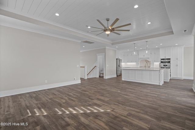 unfurnished living room featuring recessed lighting, baseboards, visible vents, a raised ceiling, and a ceiling fan