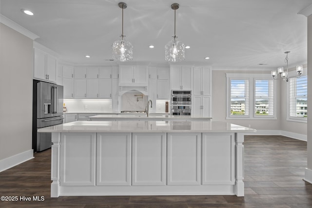 kitchen with white cabinets, appliances with stainless steel finishes, baseboards, recessed lighting, and a notable chandelier