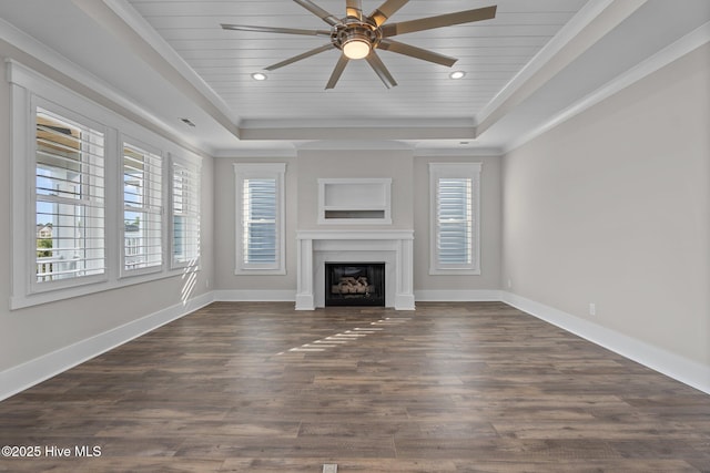 unfurnished living room featuring a fireplace, a raised ceiling, ceiling fan, and dark wood finished floors