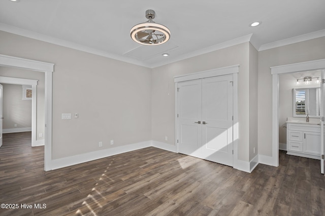 unfurnished bedroom featuring baseboards, ornamental molding, a closet, and dark wood-style floors