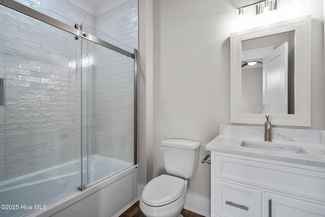 bathroom featuring toilet, combined bath / shower with glass door, wood finished floors, and vanity