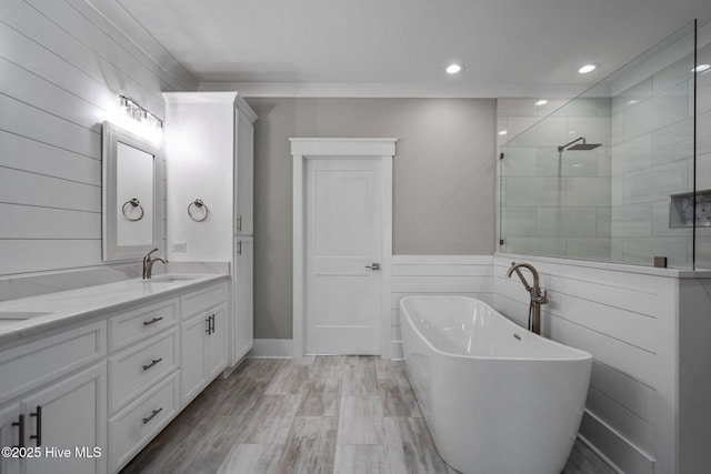 full bathroom featuring a tile shower, a soaking tub, a sink, double vanity, and recessed lighting