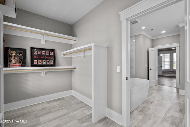 spacious closet featuring visible vents and wood finished floors