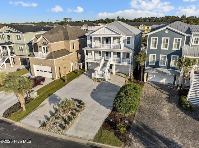 view of front of house with a balcony, driveway, a residential view, and an attached garage