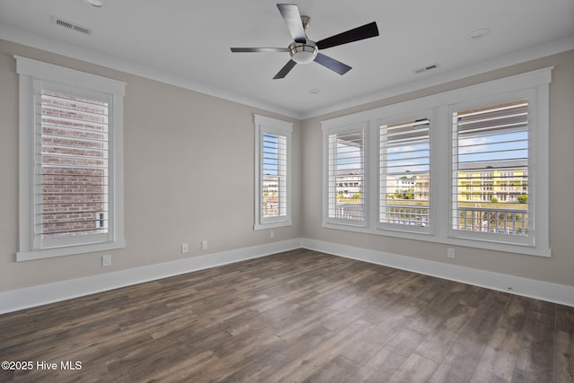 empty room with dark wood-style floors, visible vents, and baseboards