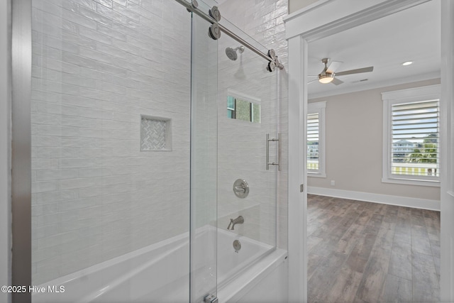 bathroom with baseboards, shower / bath combination with glass door, wood finished floors, and a ceiling fan