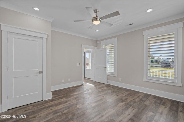 unfurnished bedroom with wood finished floors, visible vents, ornamental molding, and baseboards