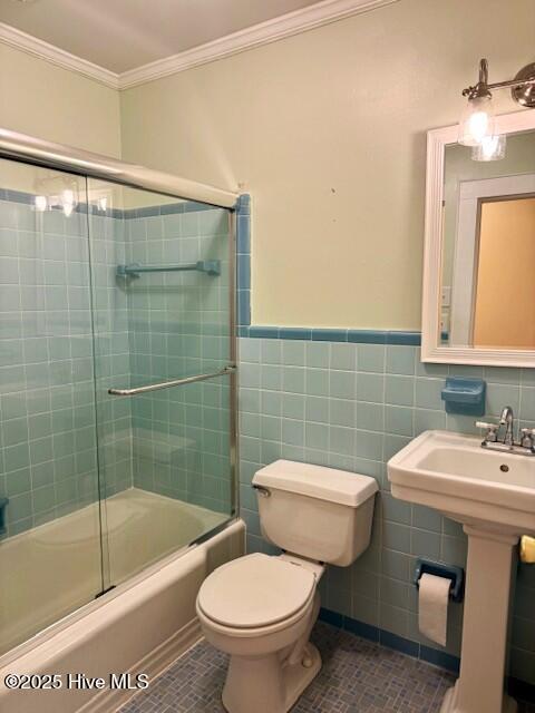 407 Main St, Bayboro, NC 28515 - bathroom with crown molding, tile patterned flooring, a wainscoted wall, toilet, and shower / bath combination with glass door