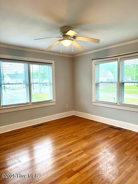 407 Main St, Bayboro, NC 28515 - empty room featuring visible vents, ornamental molding, wood finished floors, baseboards, and ceiling fan