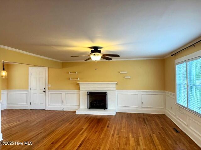 407 Main St, Bayboro, NC 28515 - unfurnished living room featuring ceiling fan, ornamental molding, and wood finished floors