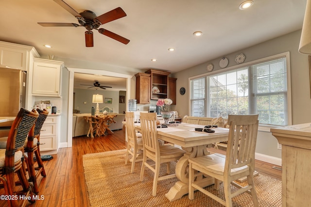 dining space with light wood-type flooring, recessed lighting, ceiling fan, and baseboards