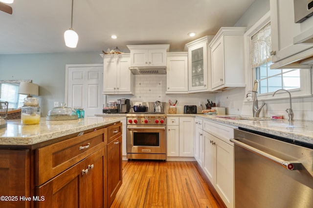 kitchen featuring recessed lighting, light stone countertops, decorative backsplash, white cabinetry, and appliances with stainless steel finishes