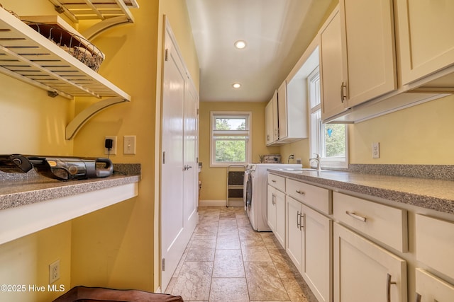 laundry room with recessed lighting, a sink, cabinet space, separate washer and dryer, and baseboards