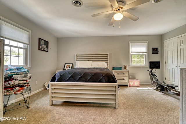 bedroom featuring a closet, carpet flooring, baseboards, visible vents, and a ceiling fan