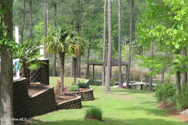 view of home's community featuring a forest view, a gazebo, and a lawn