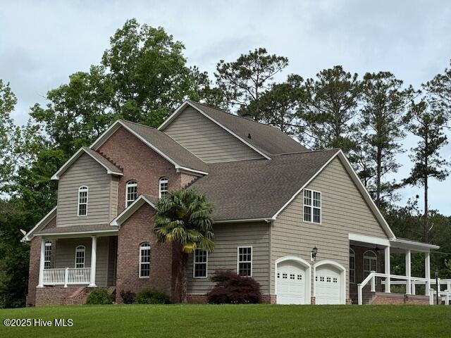 view of property exterior featuring a yard, covered porch, and an attached garage