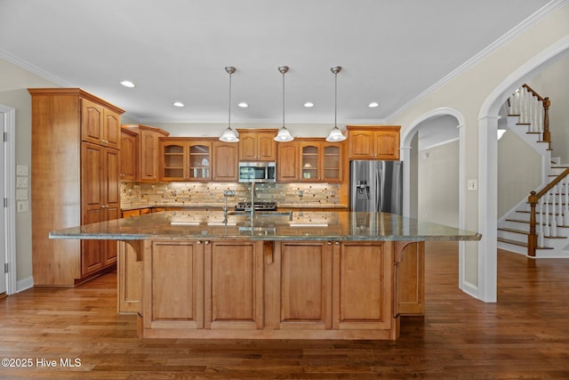 kitchen with brown cabinetry, stainless steel appliances, and a kitchen bar