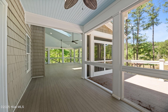unfurnished sunroom featuring a ceiling fan and beam ceiling