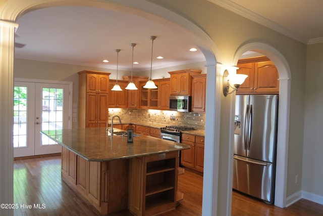 kitchen with stainless steel appliances, dark wood finished floors, french doors, and brown cabinets
