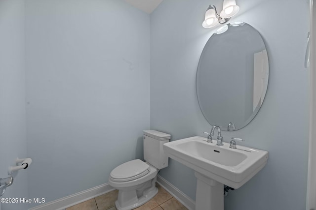 bathroom with toilet, tile patterned flooring, and baseboards