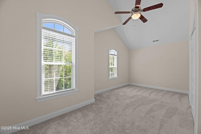 unfurnished room with baseboards, ceiling fan, visible vents, vaulted ceiling, and light colored carpet
