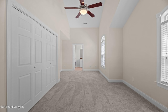 hall featuring a wealth of natural light, light carpet, baseboards, and visible vents