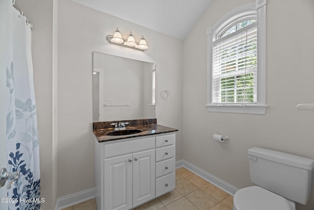 bathroom featuring lofted ceiling, toilet, plenty of natural light, and tile patterned flooring
