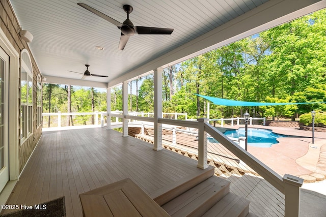 wooden deck featuring a ceiling fan and an outdoor pool