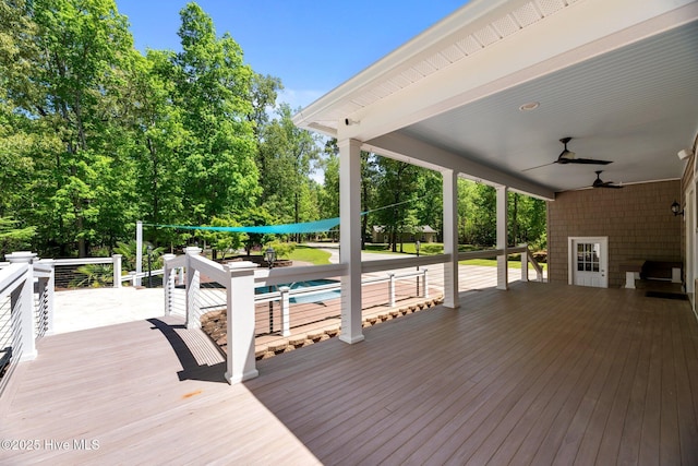 deck featuring a ceiling fan and an outdoor pool