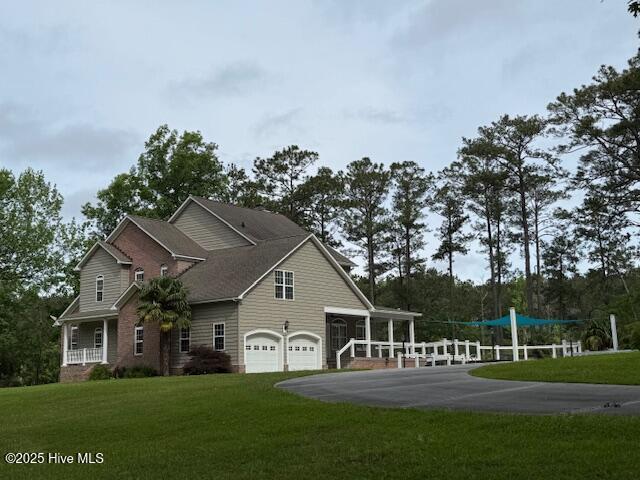 view of home's exterior featuring a lawn, aphalt driveway, and an attached garage