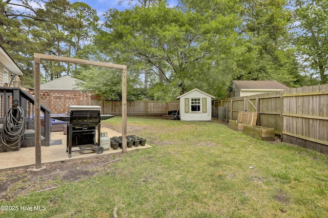 view of yard with an outbuilding, a storage unit, and a fenced backyard