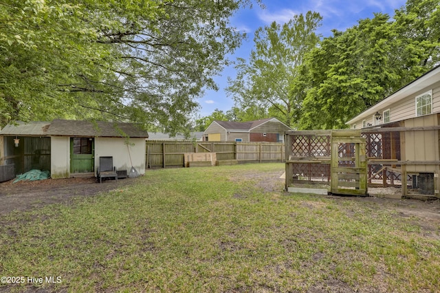 view of yard featuring a storage shed, an outbuilding, and a fenced backyard