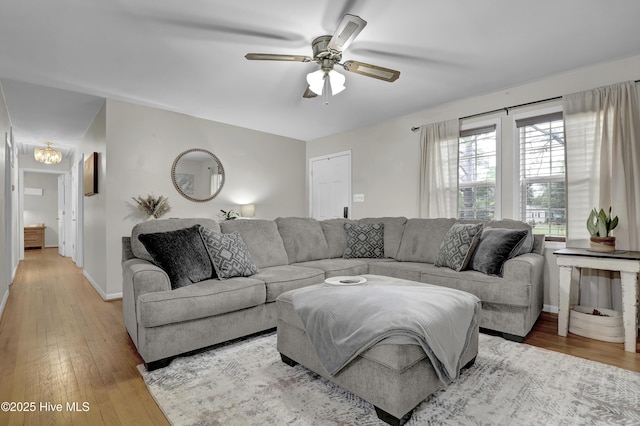 living room with ceiling fan, light wood finished floors, and baseboards