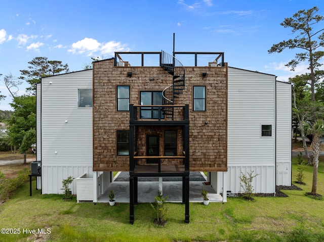 back of property with a lawn and a balcony