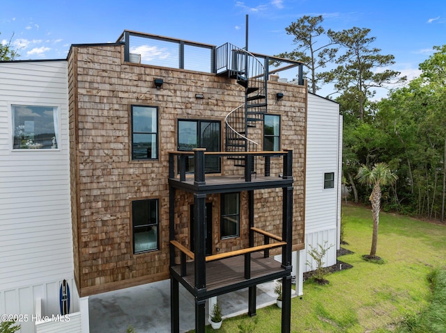 rear view of property featuring a balcony and a yard