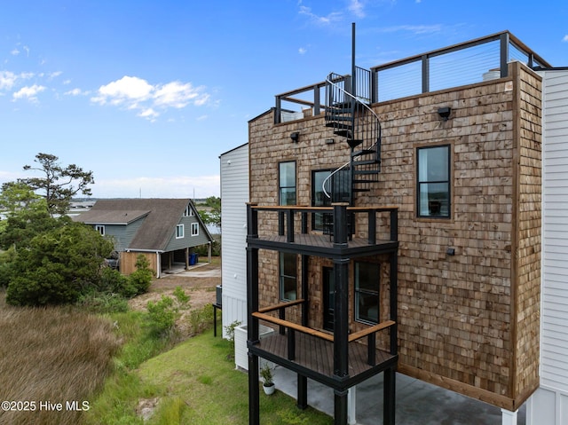 rear view of house with stairway and a balcony