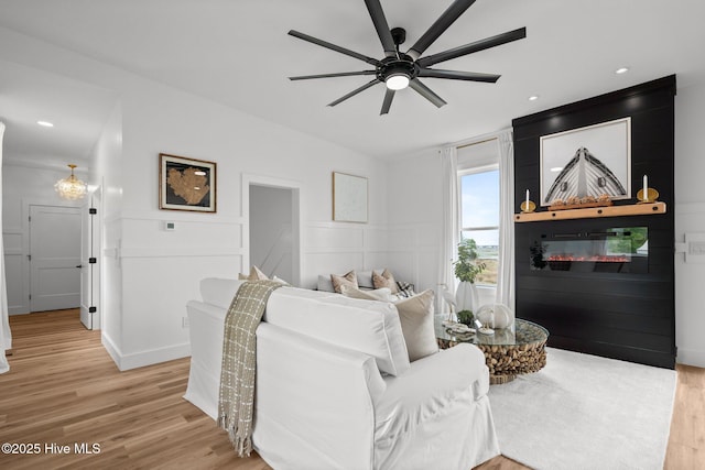 living room featuring ceiling fan, recessed lighting, light wood-type flooring, and a wainscoted wall